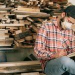 Montre un artisan ou un travailleur indépendant concentré sur son activité, dans un atelier ou un espace de travail personnel